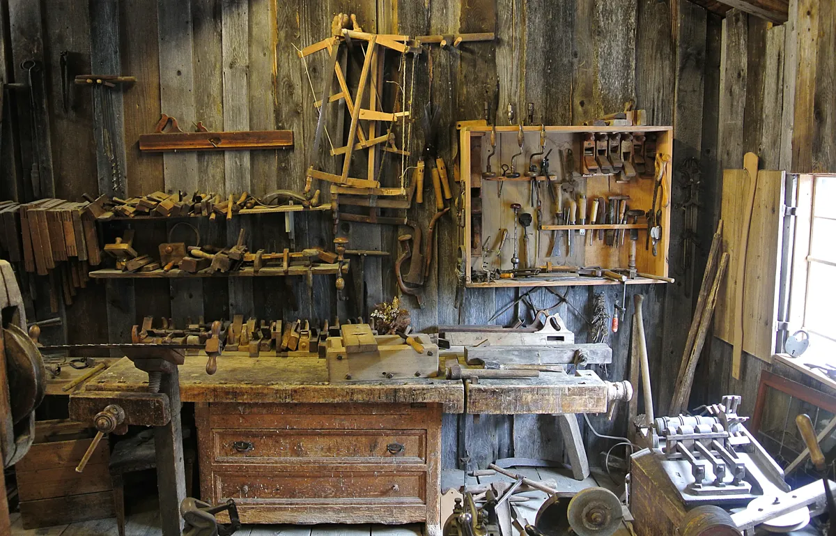 Cluttered woodworking workshop with benches and tools